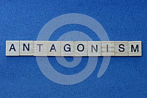 Gray word antagonism in small square wooden letters photo