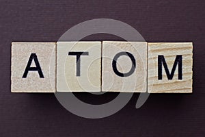 Gray word atom from small wooden letters