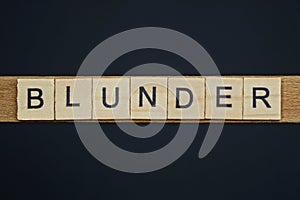 Gray word blunder from small wooden letters