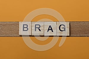 Gray word brag made of wooden square letters