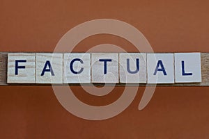 Gray word factual made of wooden square letters