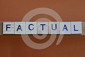 Gray word factual made of wooden square letters photo