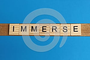 Gray word immerse in small square wooden letters