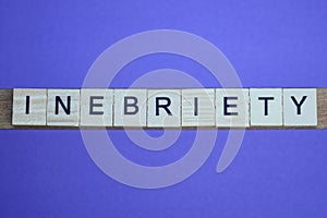 Gray word inebriety in small square wooden letters