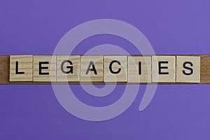 Gray word legacies in small square wooden letters photo