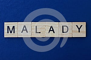 gray word malady in small square wooden letters