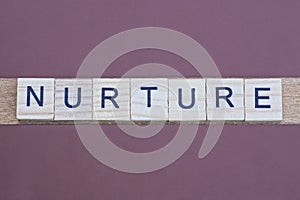 gray word nurture made of wooden square letters