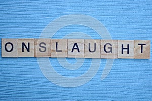 Gray word onslaught from small wooden letters