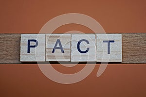 Gray word pact made of wooden square letters photo