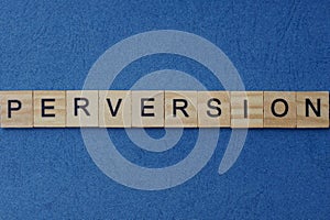Gray word perversion in small square wooden letters photo