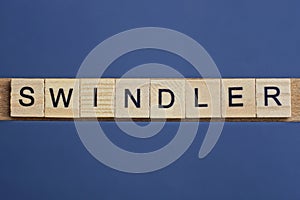 Gray word swindler from small wooden letters