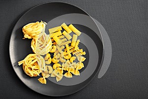 Gray and yellow colors with various kind of pasta and gray background