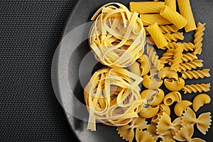 Gray and yellow colors with various kind of pasta and gray background