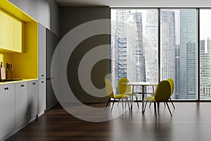 Gray and yellow kitchen interior with dining table