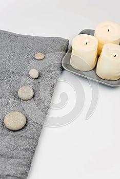 Gray zen pebble hot stones with towel on massage table in beauty salon. Hot stone massage setting.