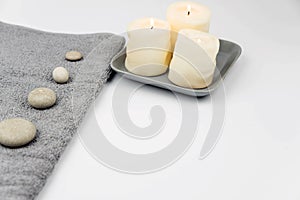 Gray zen pebble hot stones with towel on massage table in beauty salon. Hot stone massage setting.