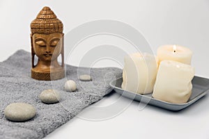 Gray zen pebble hot stones with towel on massage table in beauty salon. Hot stone massage setting.