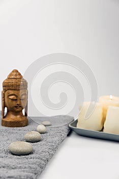 Gray zen pebble hot stones with towel on massage table in beauty salon. Hot stone massage setting.