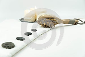 Gray zen pebble hot stones with towel on massage table in beauty salon. Hot stone massage setting.