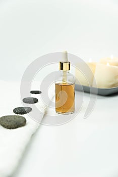 Gray zen pebble hot stones with towel on massage table in beauty salon. Hot stone massage setting.