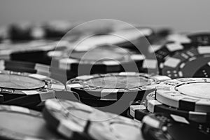 Grayscale closeup of a pile of poker chips on the table