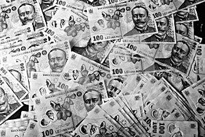 Grayscale closeup top view of a pile of 100 Romanian leu banknotes