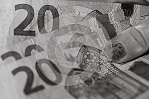 Grayscale shot of 20 euro banknotes in a woman's hand