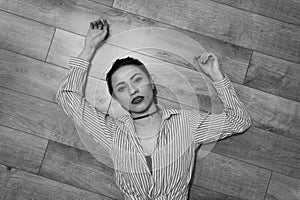 Grayscale shot of an attactive woman lying on the floor