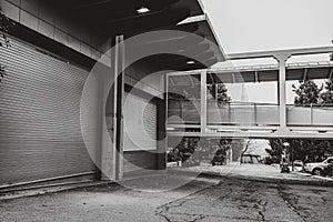 Grayscale shot of a backyard of a house with garage gates