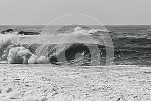 Grayscale shot of big waves crashing on the sea - perfect for background