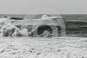 Grayscale shot of big waves crashing on the sea - perfect for background