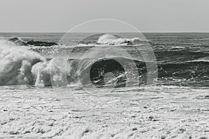 Grayscale shot of big waves crashing on the sea - perfect for background