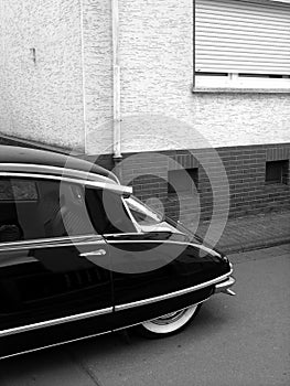 Grayscale shot of black French luxury limousine from the sixties with whitewall tires