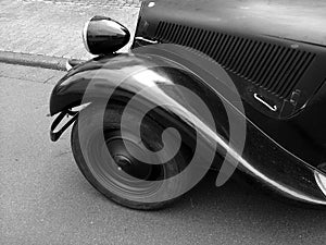 Grayscale shot of black French luxury limousine from the sixties with whitewall tires