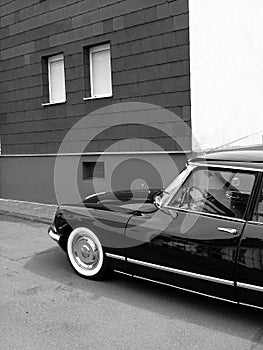 Grayscale shot of black French luxury limousine from the sixties with whitewall tires