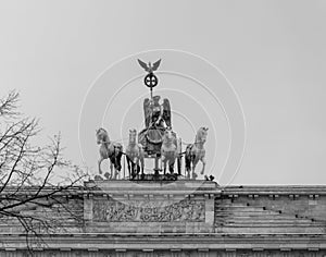 Grayscale shot of the chariot statue on the Brandenburg Gate in Berlin, Germany under a clear sky