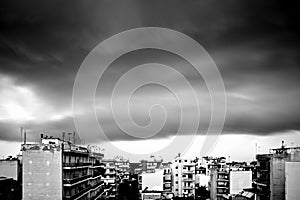 Grayscale shot of the city of Patras in Greece under storm clouds