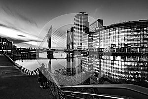 Grayscale shot of a couple enjoying the view of the Quays in Salford