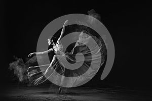 Grayscale shot of an emotional Southeast Asian ballet dancer performing a move on a black background