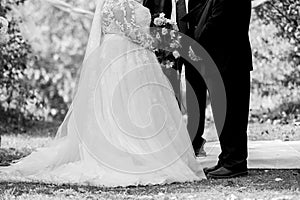 Grayscale shot of a loving couple getting married outdoors