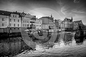 Grayscale shot of the Millrace Channel surrounded by buildings in Opole, Poland photo