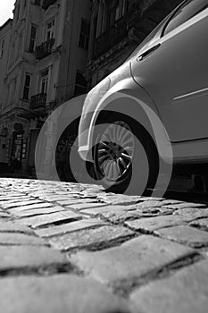 Grayscale shot of a modern sports car on the paved road on a sunny day