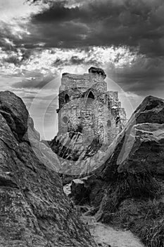 Grayscale shot of the Mow Cop Castle under a cloudy sky in England, the UK