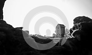 Grayscale shot of an old abandoned windmill