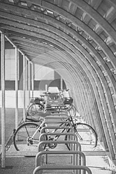 Grayscale shot of parking bicycles with several bikes