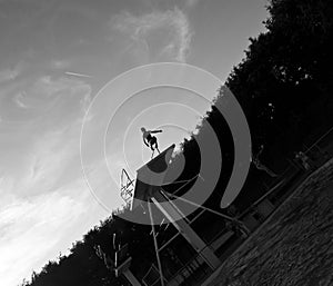 Grayscale shot of a person jumping off a board into the pool