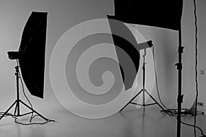 Grayscale shot of a photoshoot studio with three lightboxes on a white screen background.