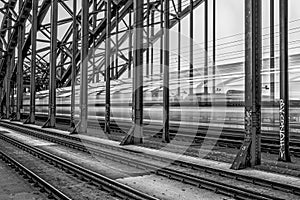 Grayscale shot of a railway and a train movingin long exposure