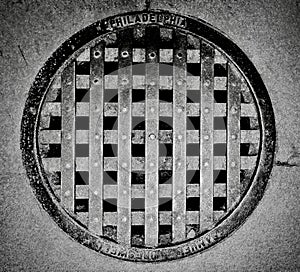 Grayscale shot of a sewer cover at the Eastern State Penitentiary in Philadelphia, Pennsylvania