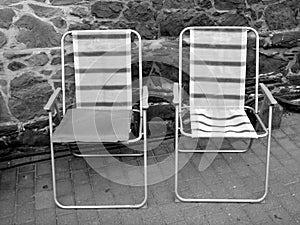 Grayscale shot of two folding chairs